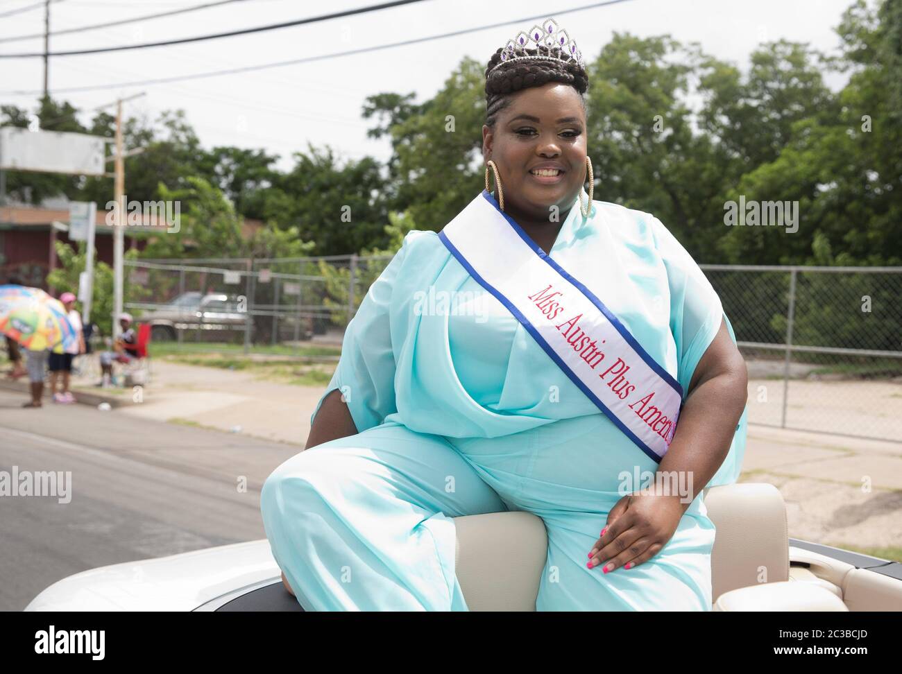 Sfilata del Junetsex--Austin, Texas USA, Giugno 21 2014: Giovane donna nera incoronata Miss Austin Plus America cavalca in auto convertibile mentre la sfilata annuale del Junetsex procede attraverso East Austin come parte di una celebrazione di un giorno. Il Giunetseesimo, conosciuto anche come "giorno della libertà" o "giorno dell'emancipazione", celebra la fine della schiavitù negli Stati Uniti alla fine della guerra civile, o guerra tra gli Stati. ©Marjorie Kamys Cotera/Daemmrich Photography Foto Stock