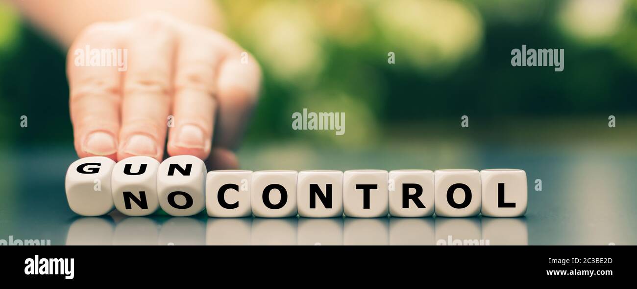La mano gira i dadi e cambia l'espressione 'no control' in 'gun control'. Foto Stock