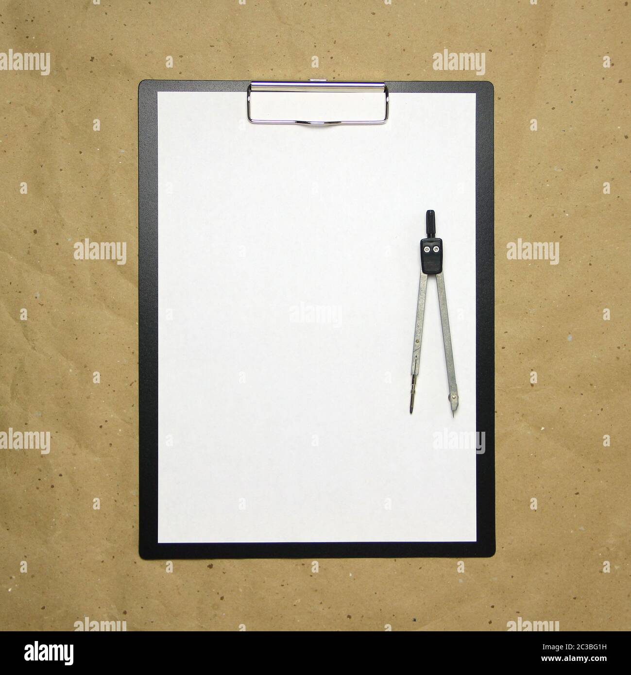 Una tavoletta con un foglio bianco di formato A4 con divisori su una carta da artigianato beige. Concetto di misurazioni, studi e costruzioni accurate. Foto di scorta con spazio vuoto per il testo e il disegno. Foto Stock