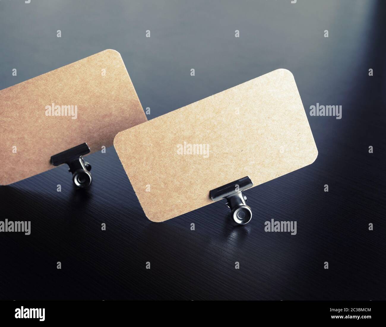 Blank vintage business cards nel legante in metallo clip nero su sfondo di legno. Modello per il branding ID. Foto Stock