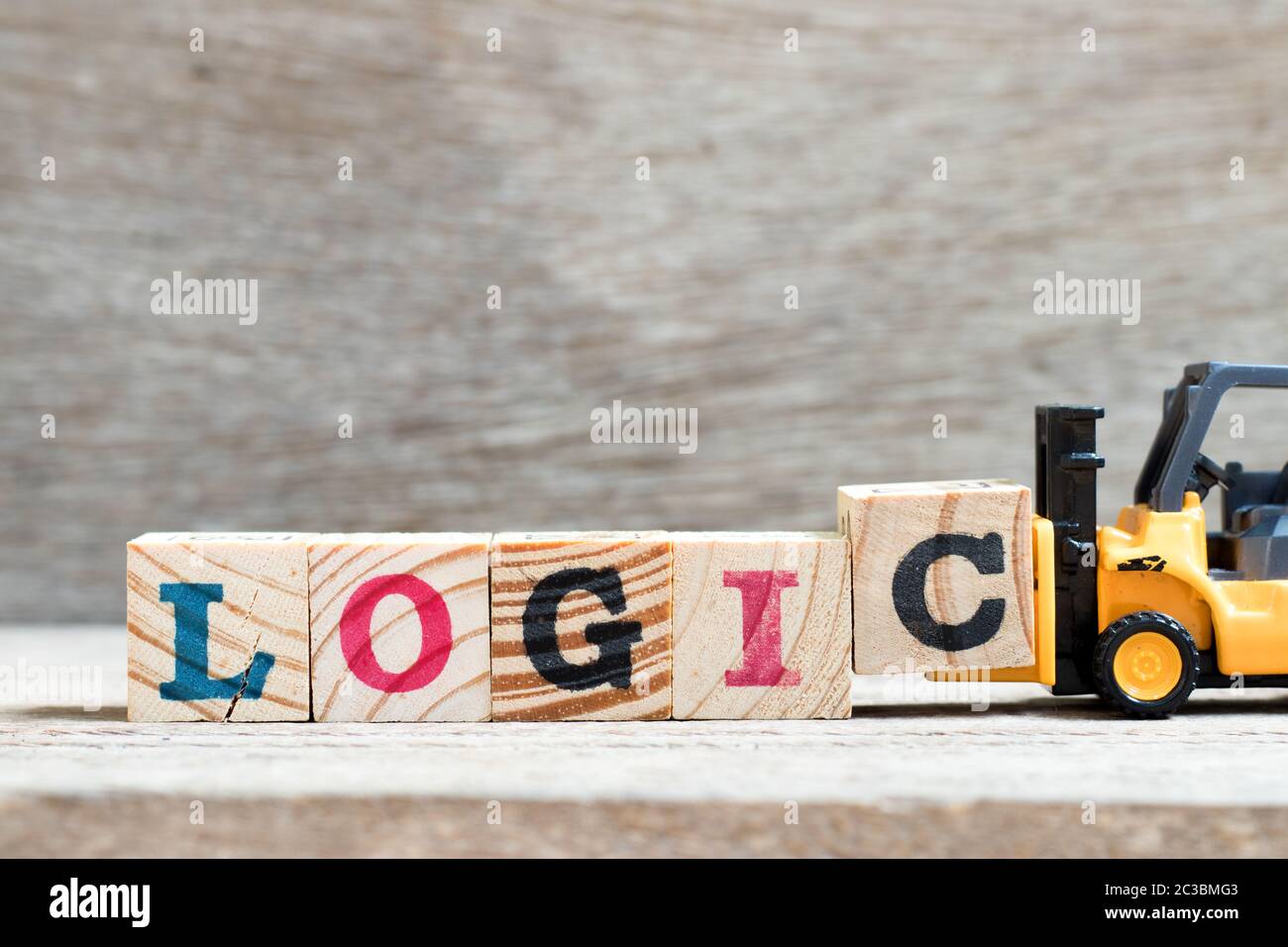 Carrello elevatore giocattolo tenere il blocco di lettera c per completare la logica di parola su sfondo legno Foto Stock