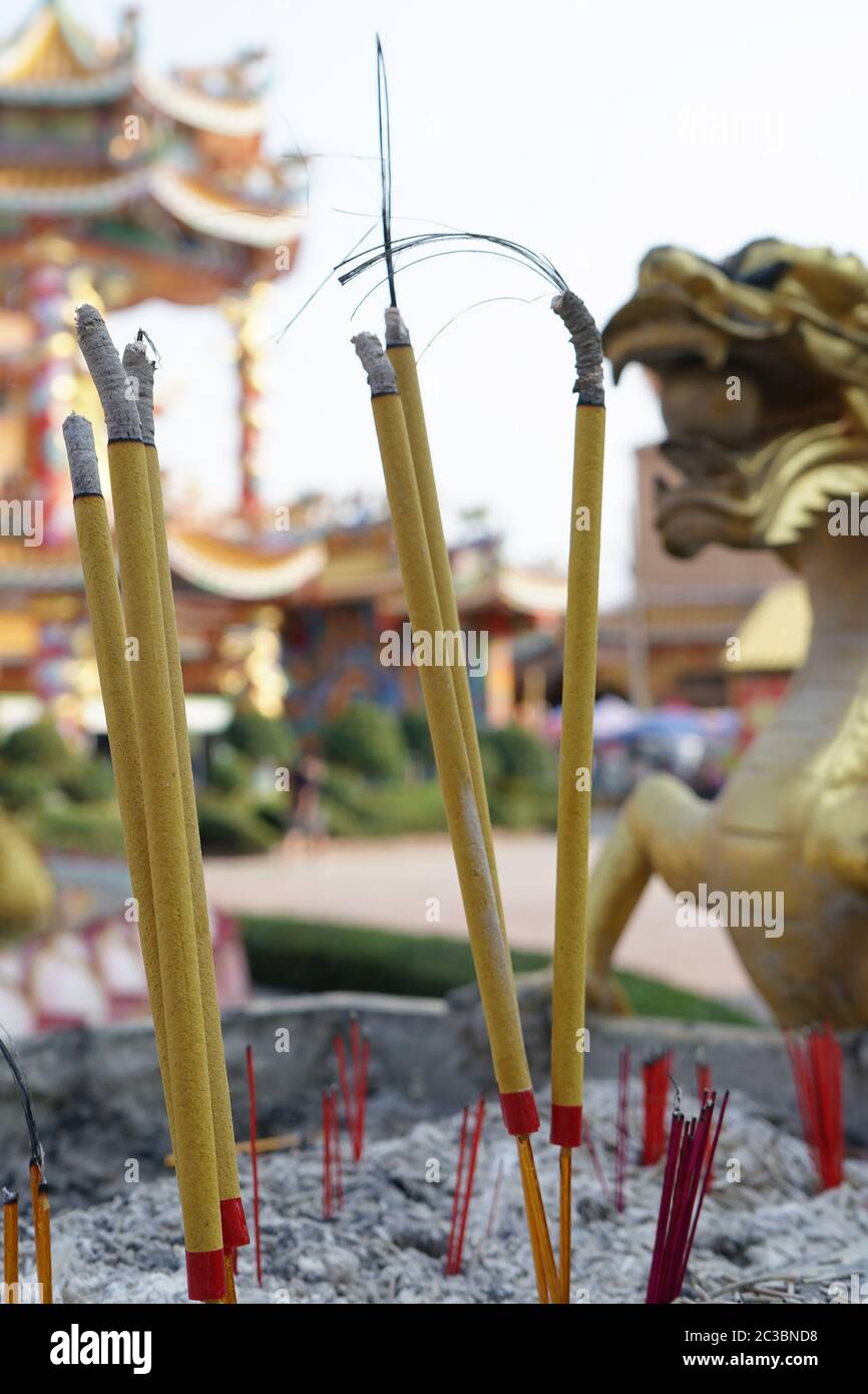 Incensi bruciati a metà strada con la struttura cinese tempio sullo sfondo. Foto Stock