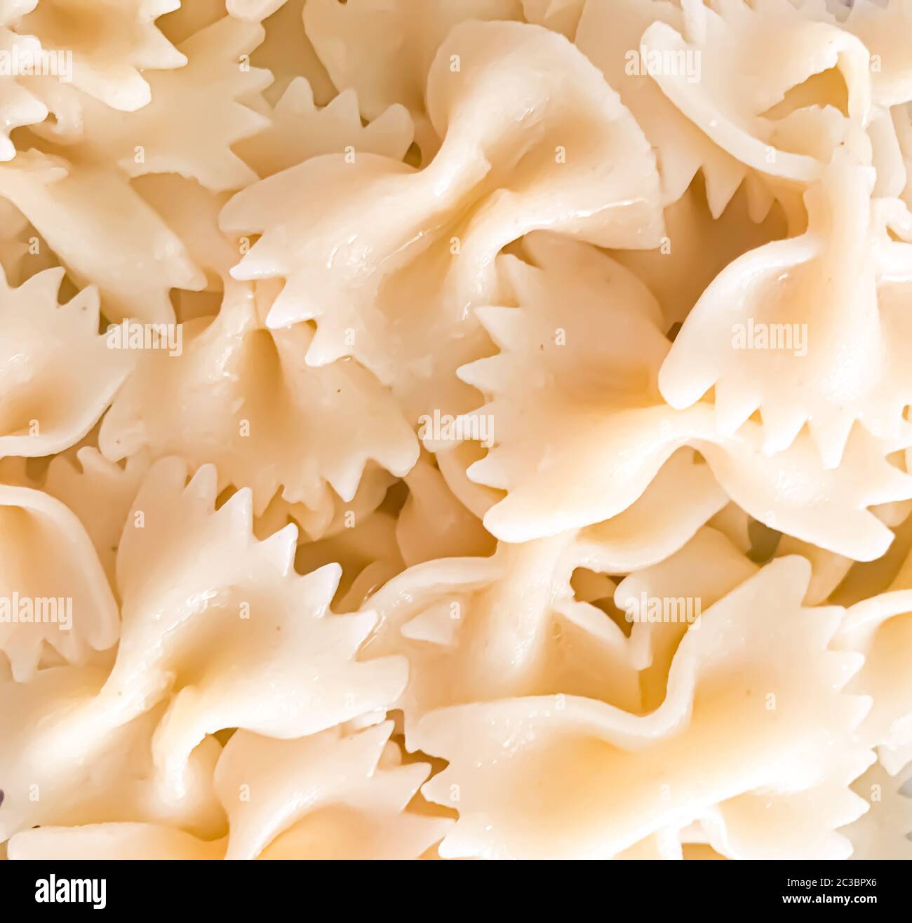 Primo piano di fondo di pasta di farfalle. Le farfalle sono un tipo di pasta/noodle comunemente noto come pasta con cravatta o pasta con farfalla. Foto Stock