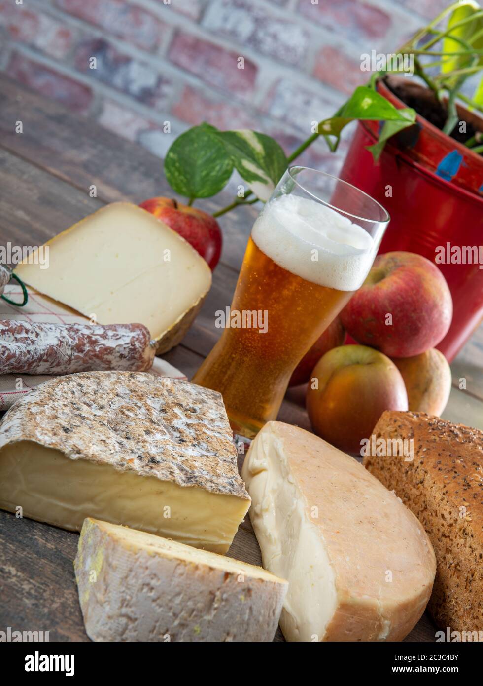 Formaggi e Tomme de Savoie con un bicchiere di birra, formaggio francese Savoia, sulle alpi francesi Francia. Foto Stock