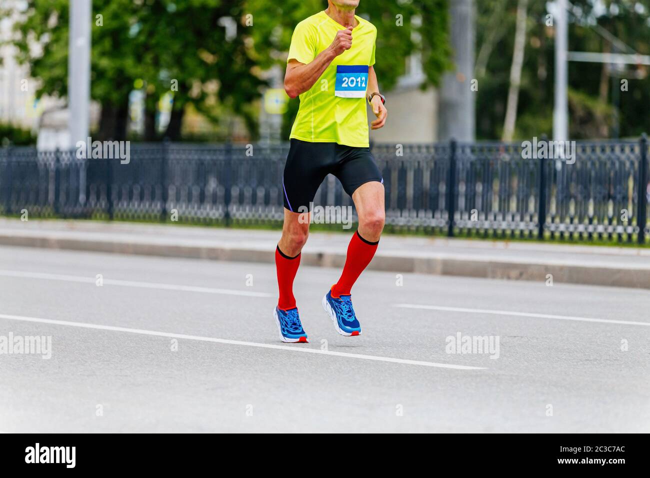 atleta di runner in calze a compressione che corrono la maratona della città Foto Stock