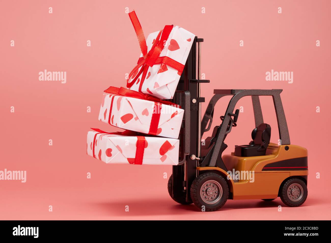 Carrelli elevatori e scatole regalo su sfondo rosa con spazio per la copia. San Valentino. Giorno del matrimonio Foto Stock