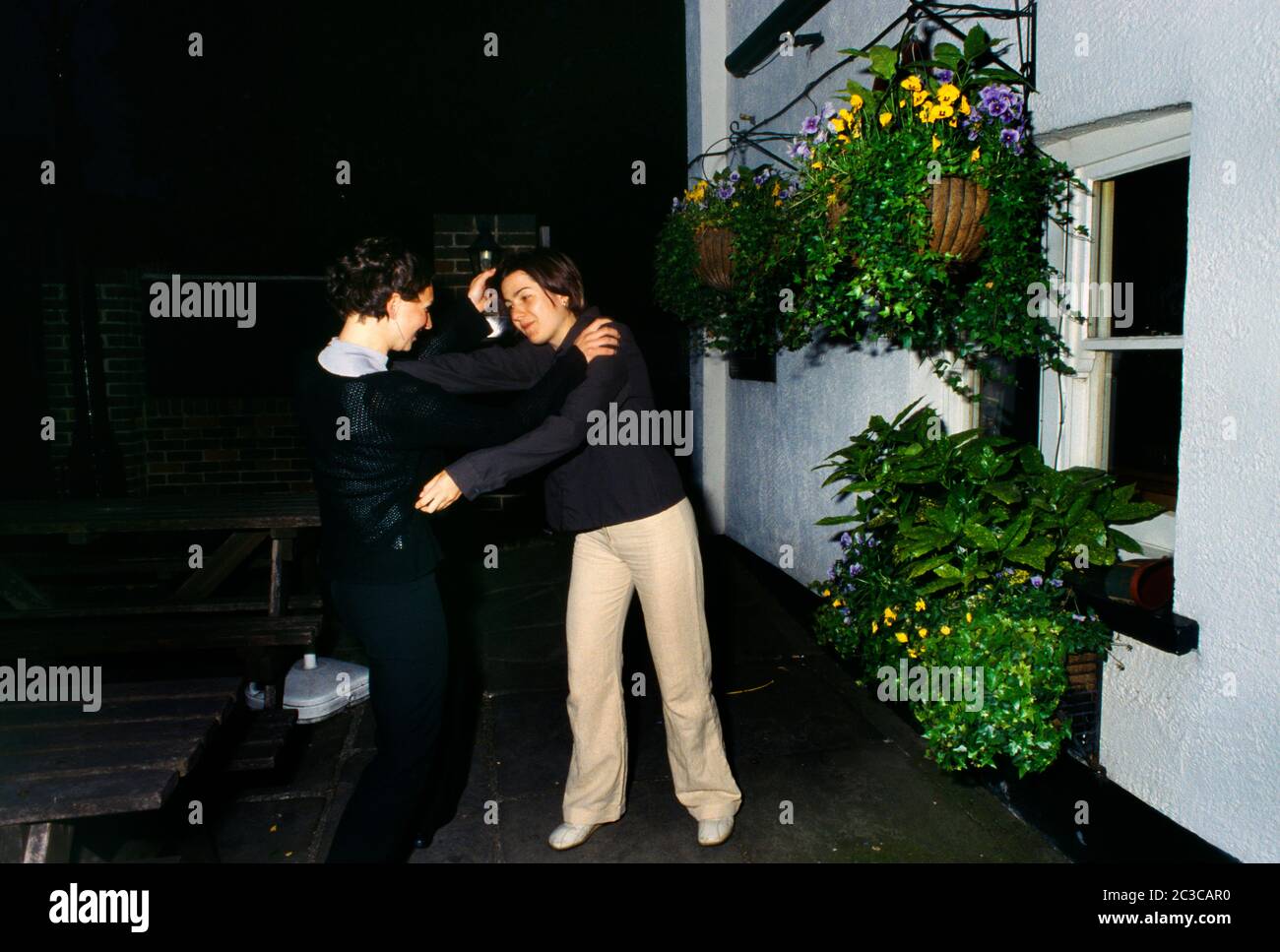 Donne combattendo fuori Pub Surrey Inghilterra Foto Stock