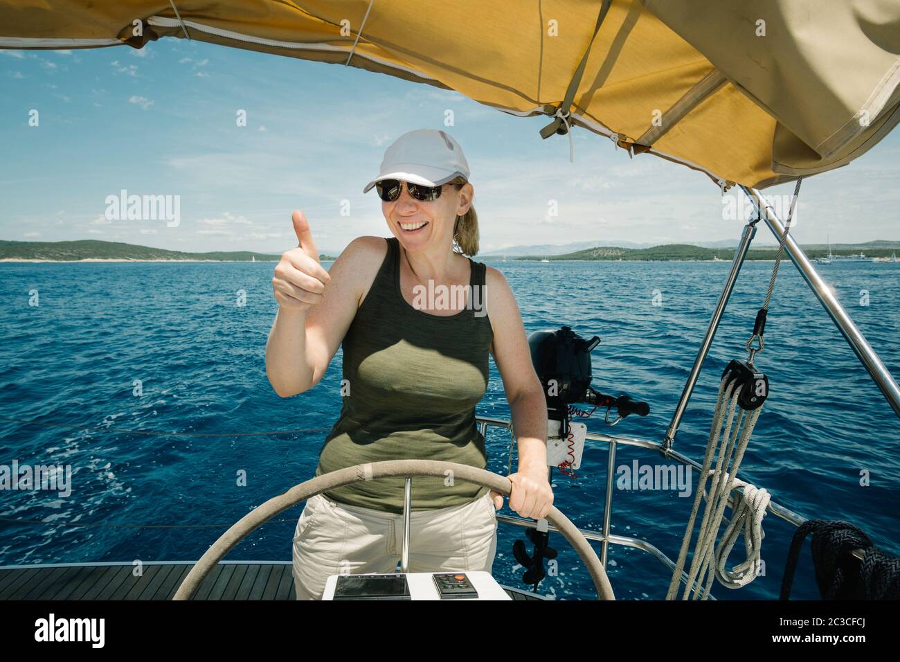 Skipper femmina sul volante di uno yacht. Concetto di vela e nautica da diporto. Foto Stock