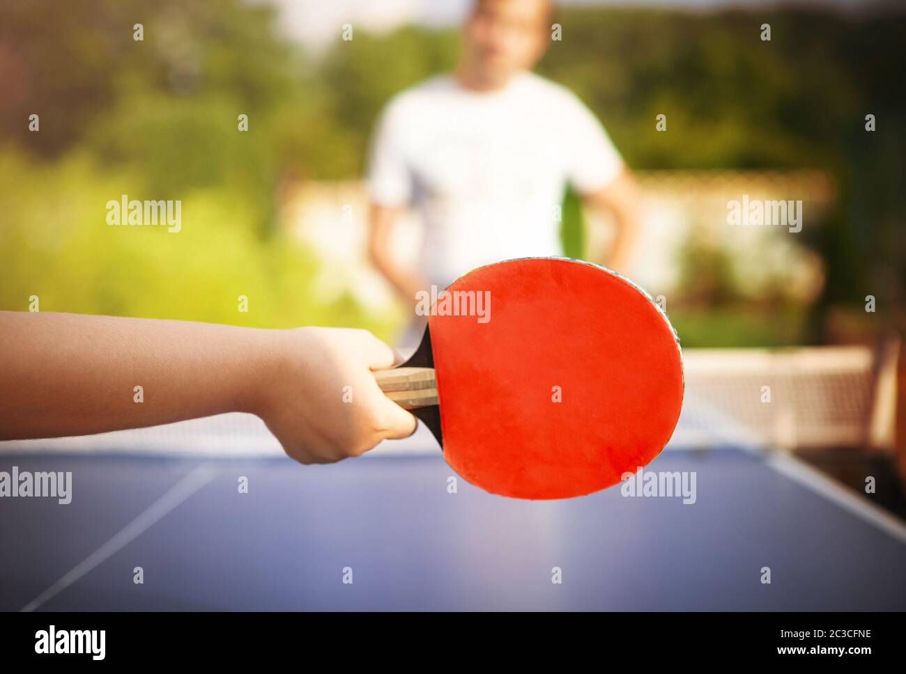 Irriconoscibile bambino che cucisce ping pong con padre Foto Stock