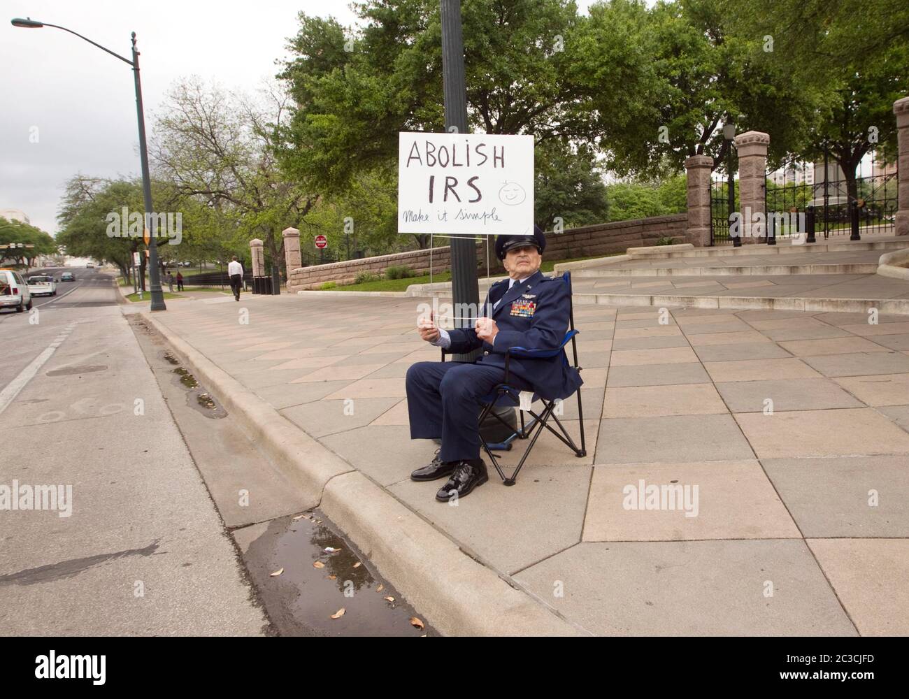 15th aprile 2013 Austin, Texas USA: Veterano militare di 93 anni si siede da solo fuori dall'edificio del Campidoglio del Texas, tenendo un cartello con la sua richiesta di abolire il Servizio Entrate interne il 15 aprile, la scadenza per cui molti americani pagano le loro tasse federali. ©Marjorie Kamys Cotera/Daemmrich Photography Foto Stock