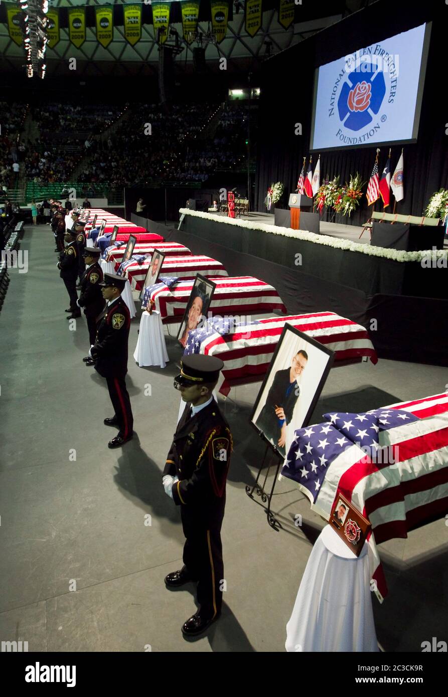 25 aprile 2013 Waco, Texas USA: I membri della guardia d'onore si trovano di fronte alle bare con bandiera mentre migliaia di lutto assistono a un memoriale per i vigili del fuoco uccisi in West, Texas, l'esplosione delle piante di fertilizzanti il 17 aprile. Dodici delle 15 persone uccise erano soccorritori. ©Marjorie Kamys Cotera/Daemmrich Photography Foto Stock