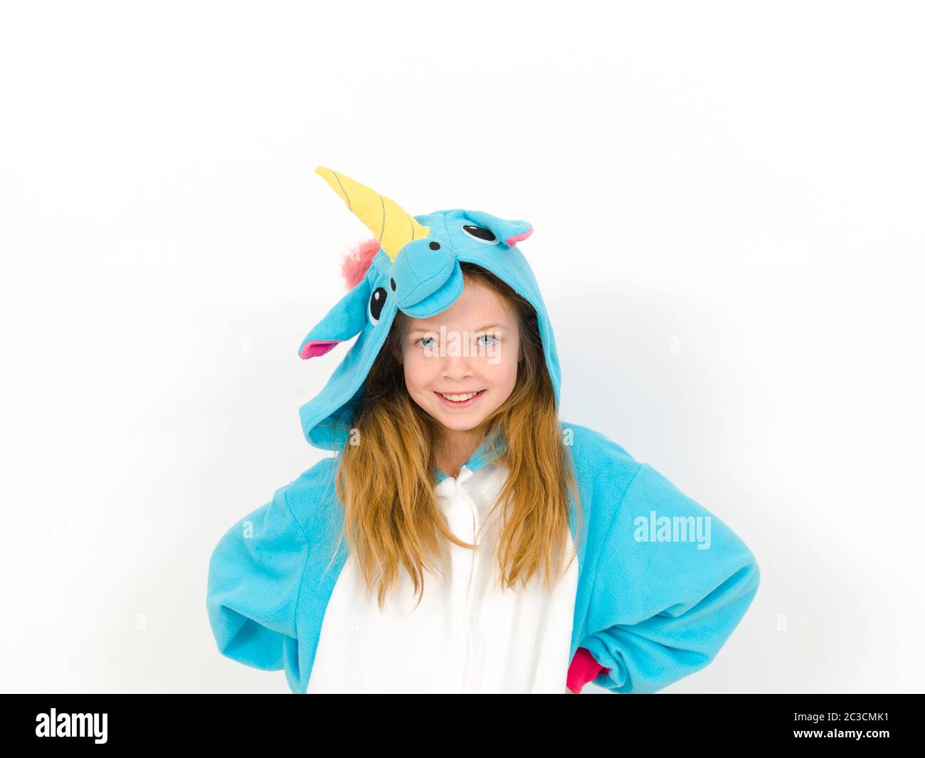 bella ragazza bionda con intimo costume unicorno blu si posa in studio di fronte al muro bianco Foto Stock