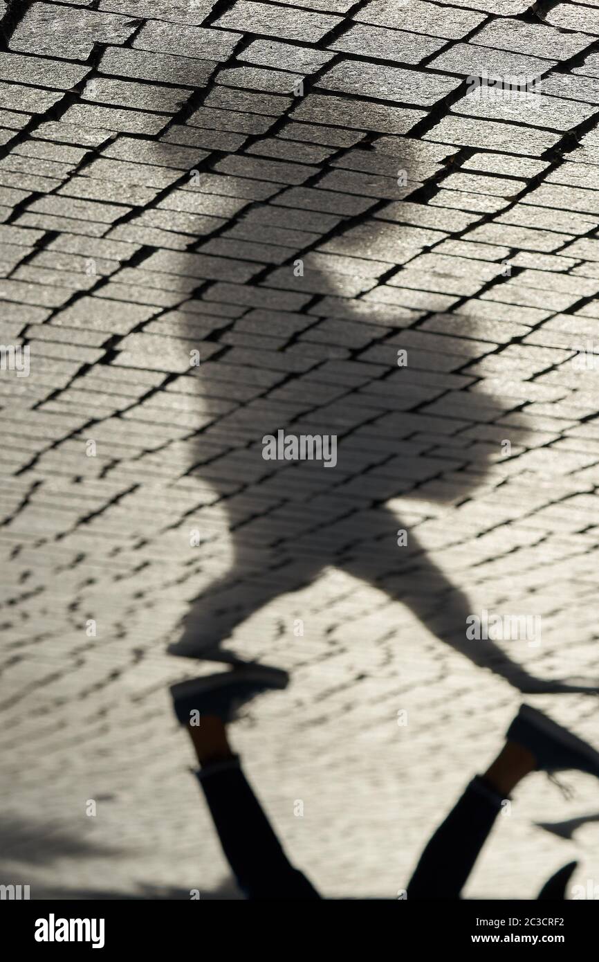 L'ombra di un pedone in una strada dello shopping a Lipsia Foto Stock