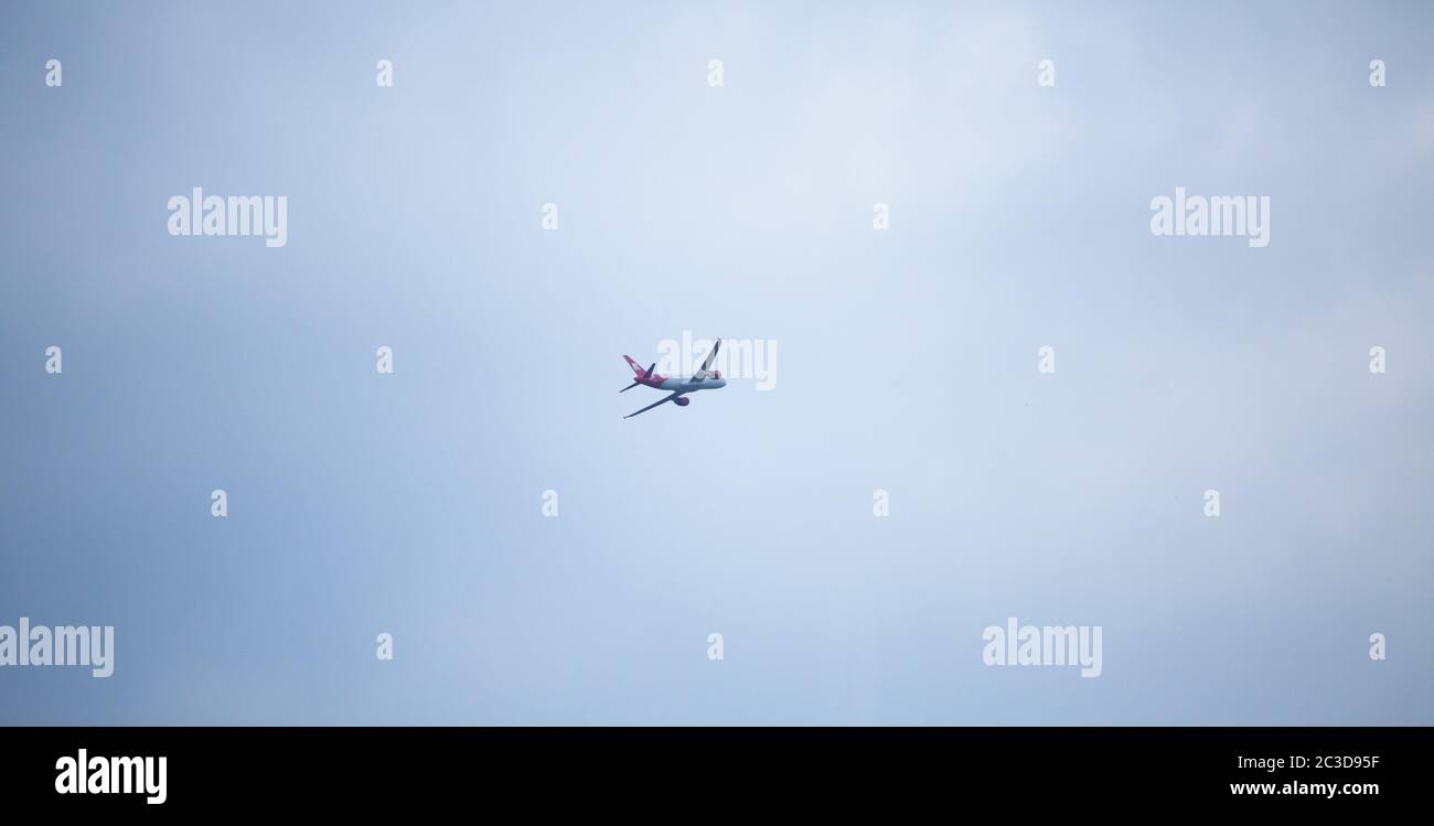 Aereo che vola in alto in cielo blu. Piano bianco con coda rossa. Aprile 2013. Vienna, Austria Foto Stock