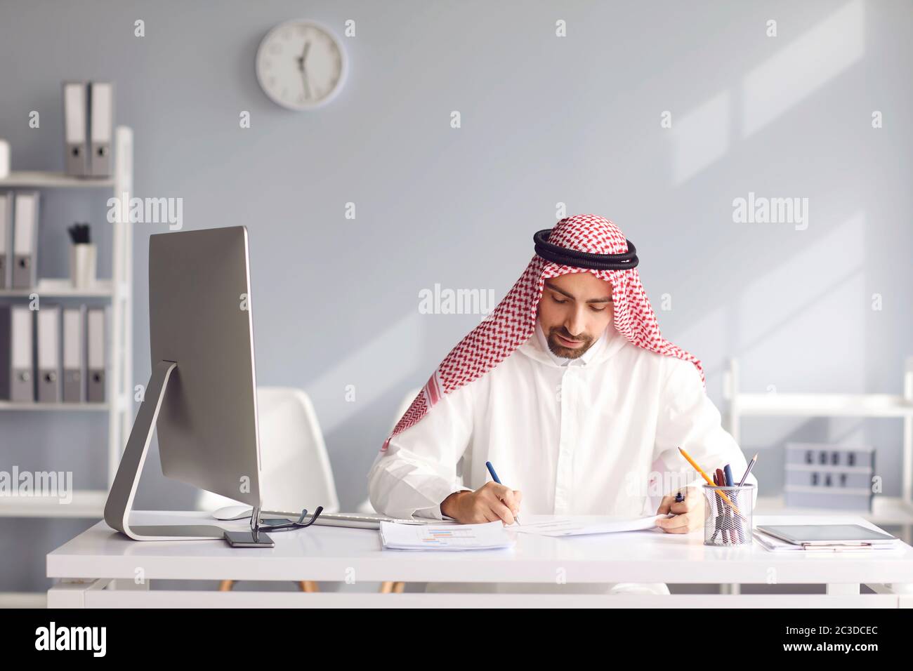 Il calmo uomo arabo siede ad un tavolo nell'ufficio. A. Foto Stock