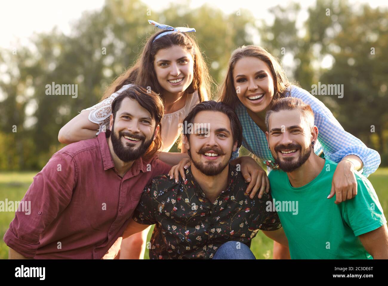 Ritratto di giovani amici che hanno tempo in campagna. Gruppo di persone felici che trascorrono il loro weekend in natura Foto Stock