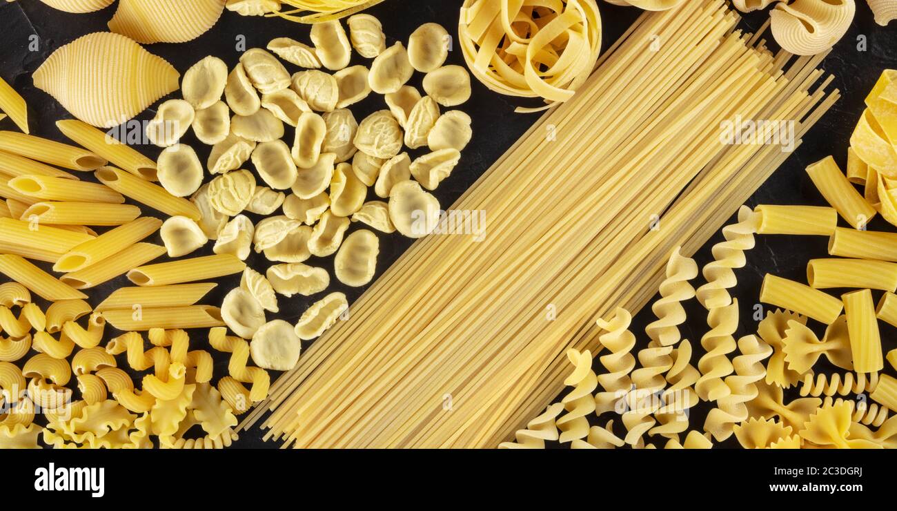 Panorama della pasta italiana, piatto di vari tipi di pasta, top shot su sfondo nero Foto Stock