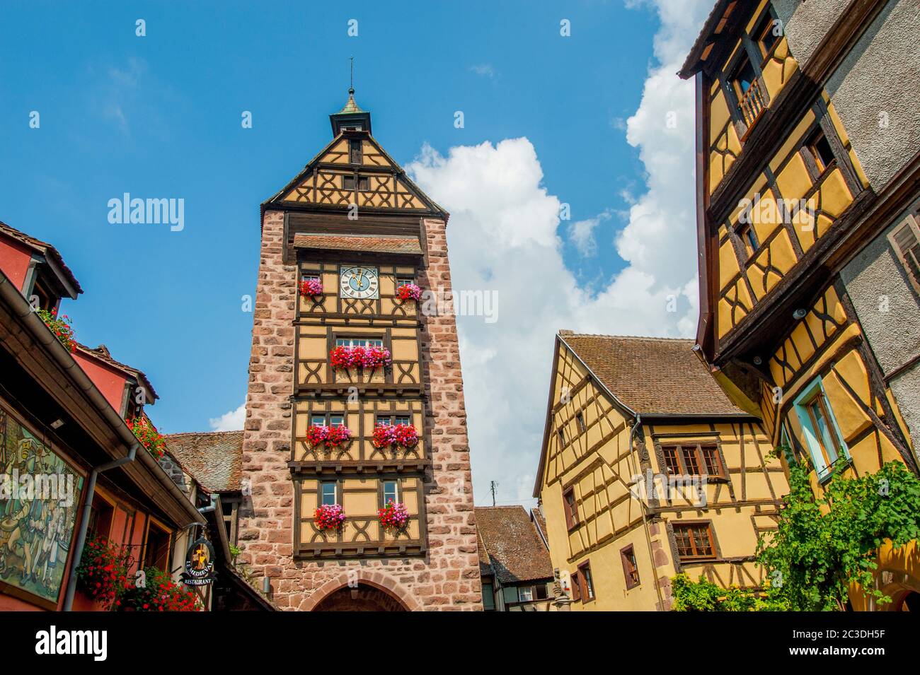La strada principale con la Torre Dolder (porta della città) nella città medievale di Riquewihr, Alsazia, nella Francia orientale. Foto Stock