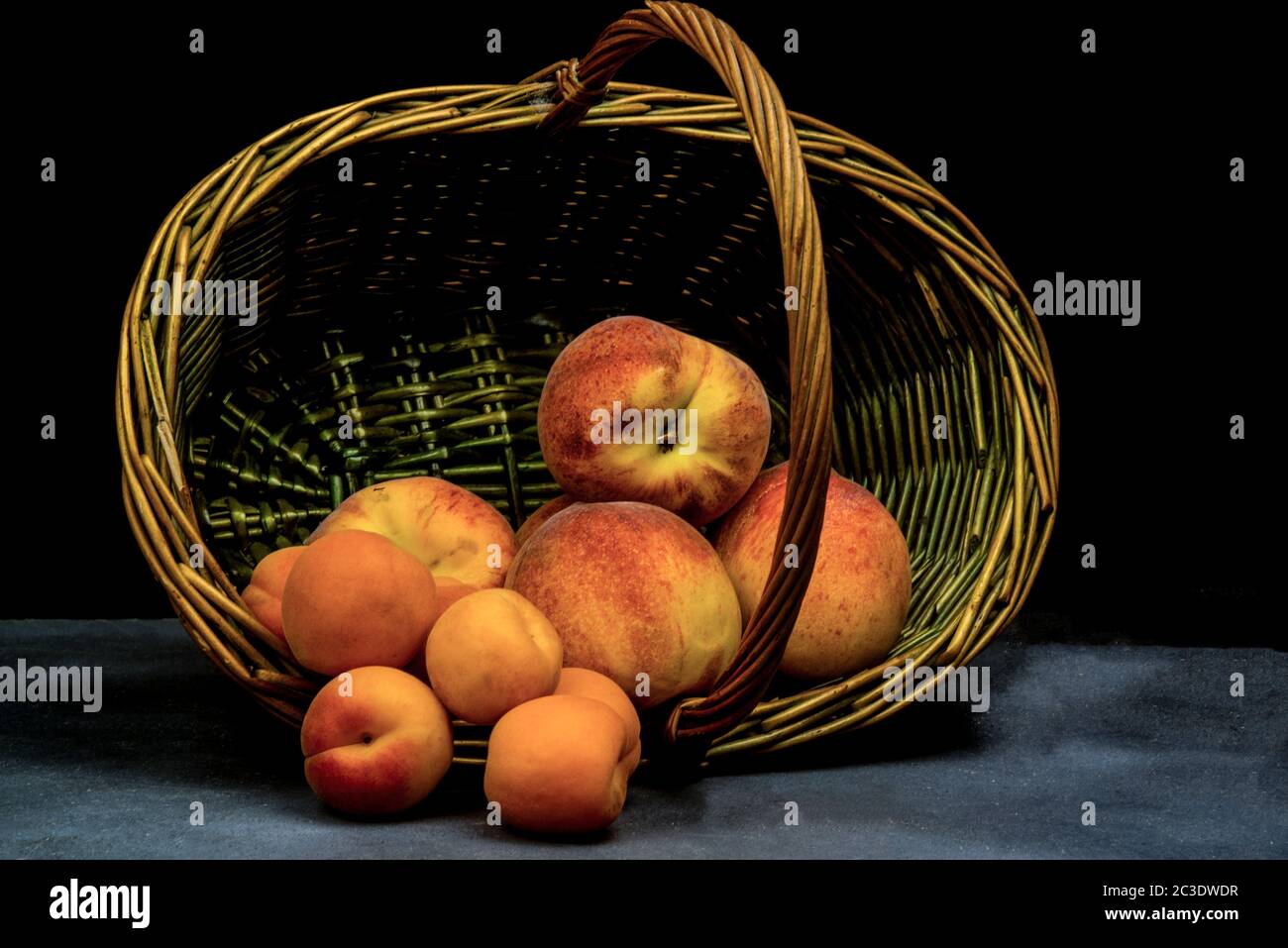 albicocche e pesche su cesto di vimini Foto Stock
