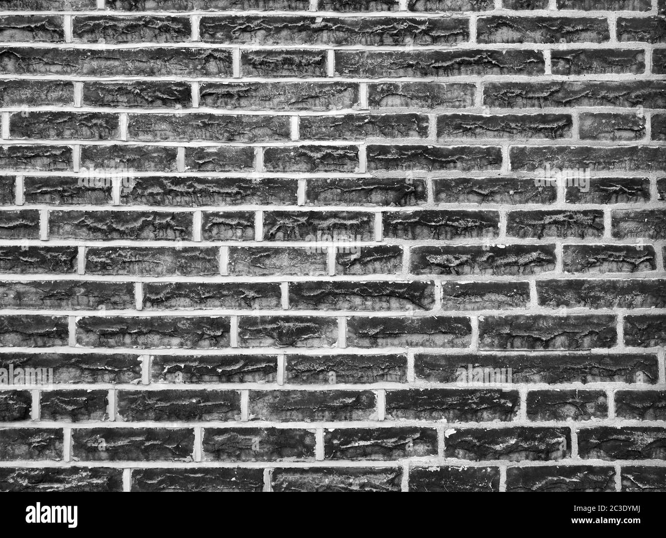 una vecchia parete fatta di mattoni di pietra neri con cemento grigio Foto Stock