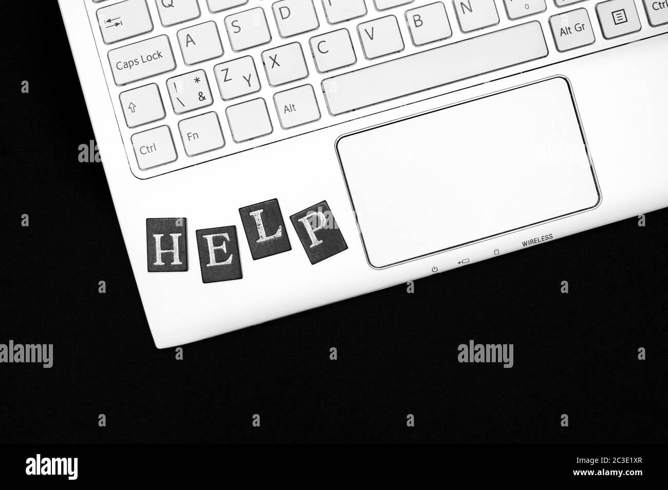 Guida - tastiera del computer portatile con lettere. Appello per risolvere problemi e problemi con il computer. Bianco e nero con spazio per la copia Foto Stock