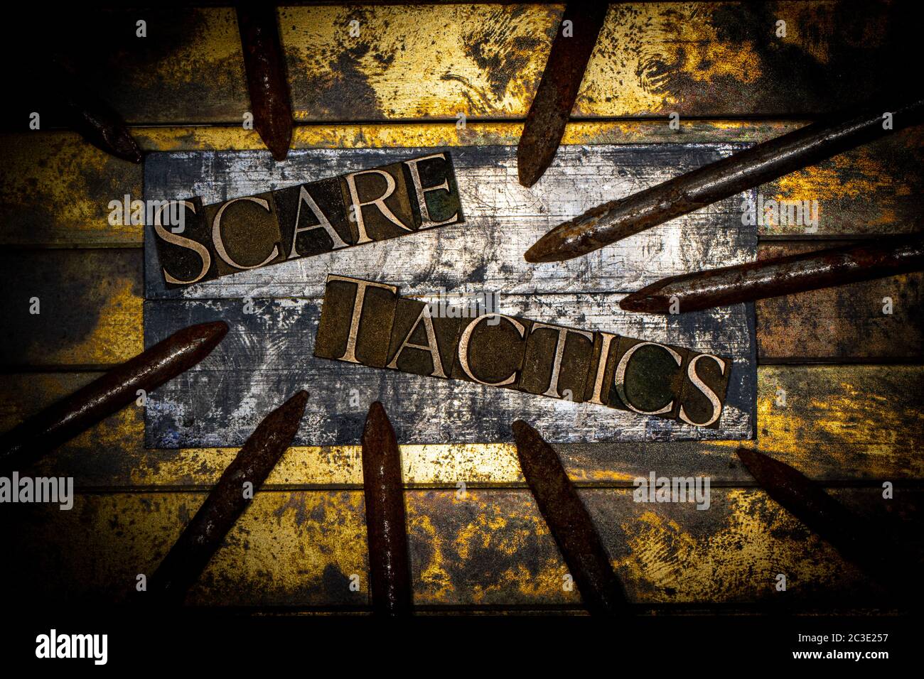 Testo Scary Tactics formato con vere e proprie lettere di typeset su vintage textured argento grunge rame e sfondo oro Foto Stock