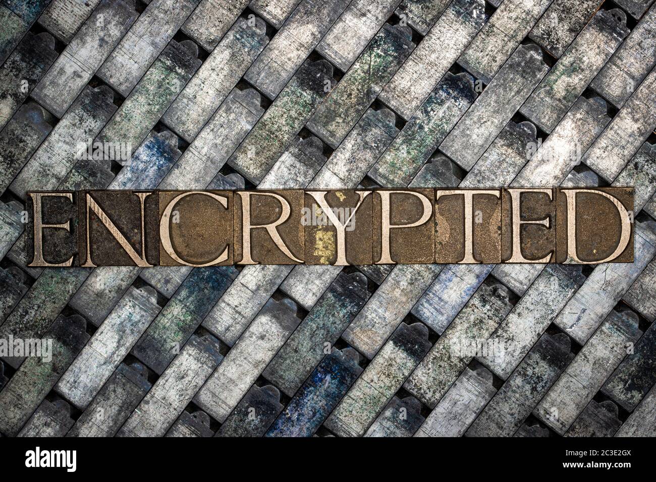 Testo cifrato formato con autentiche lettere di typeset su vintage textured argento grunge rame e sfondo oro Foto Stock