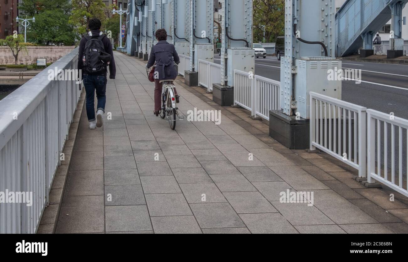 Persone che si spostano in bicicletta al ponte Eitai, Tokyo, Giappone Foto Stock