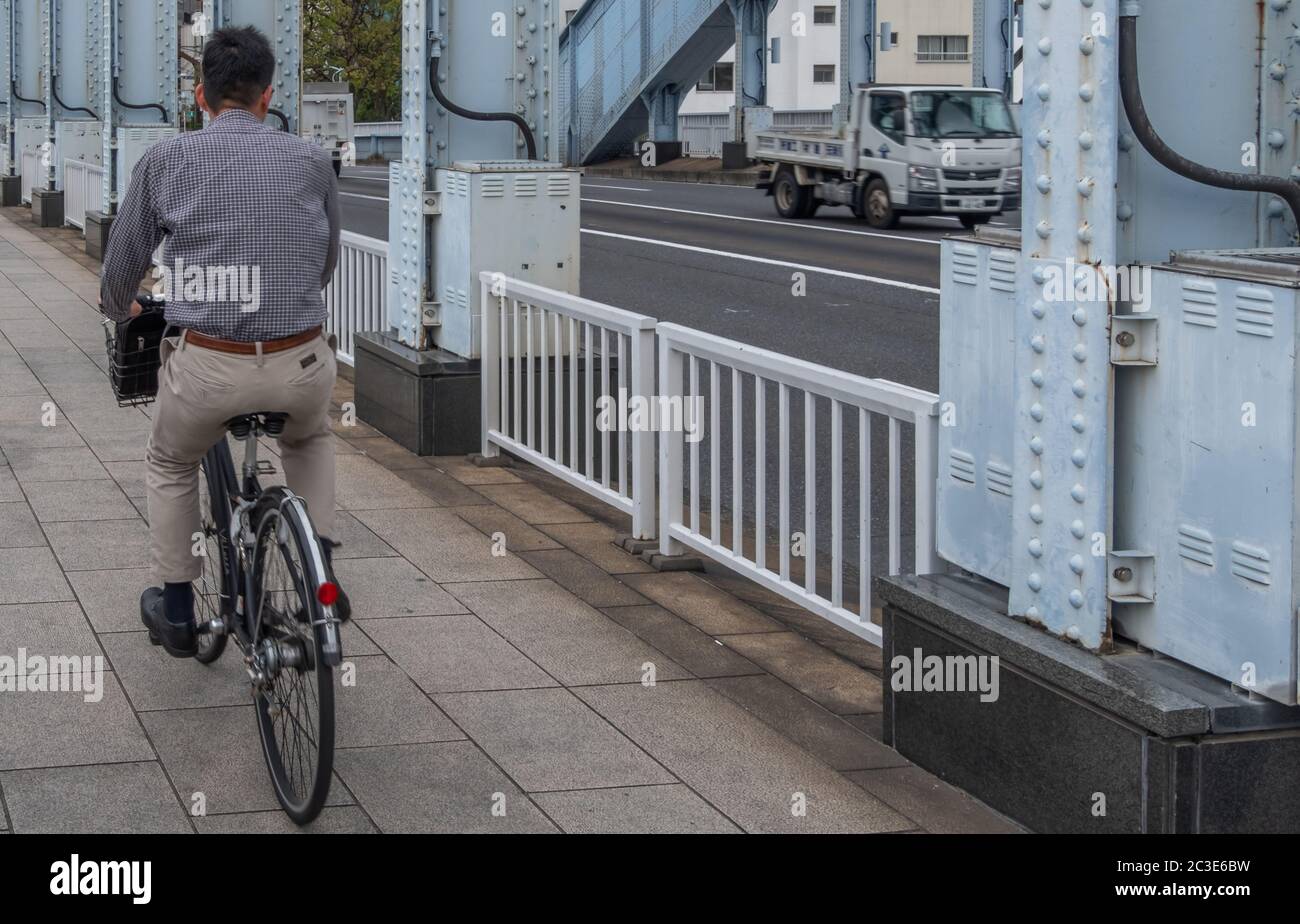 Persone che si spostano in bicicletta al ponte Eitai, Tokyo, Giappone Foto Stock
