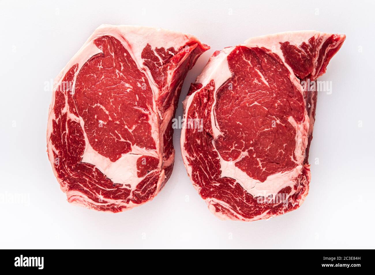 Due bistecche di ribeye disossate appena tagliate su un tavolo da macellaio Foto Stock