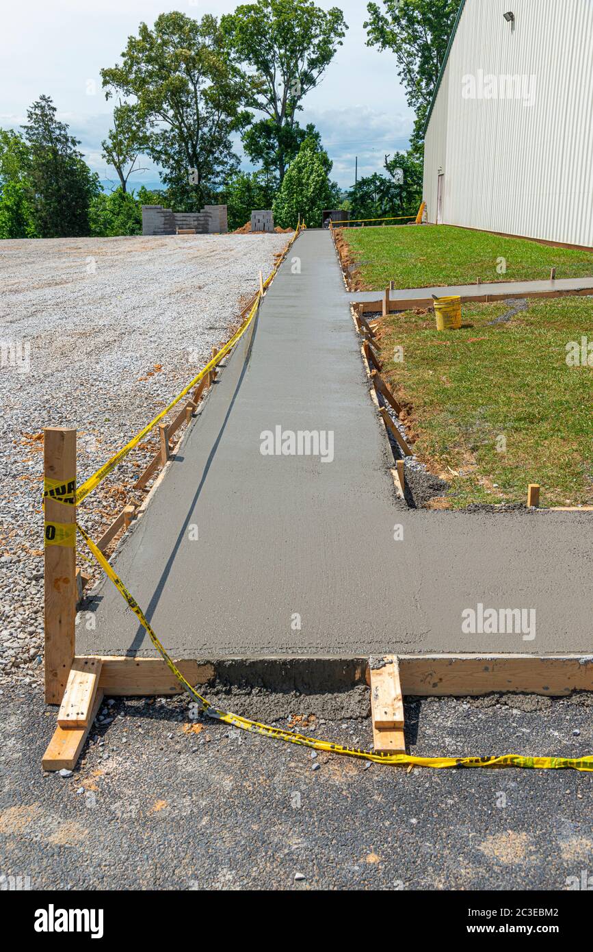 Colpo verticale di un marciapiede di cemento appena versato in un cantiere. Foto Stock