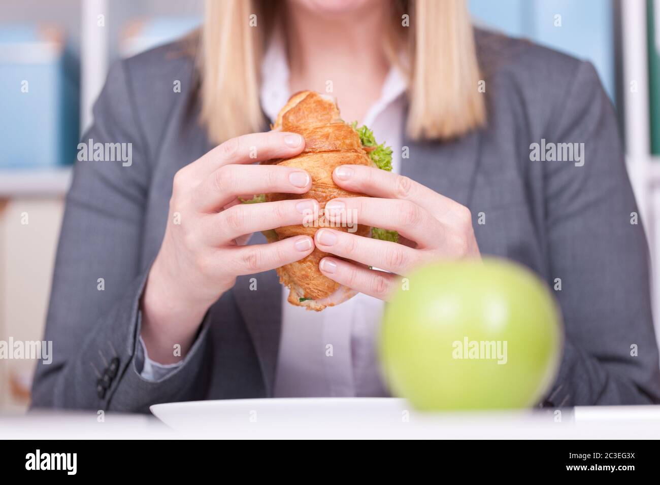 Donna in ufficio che mangia cibo durante la sua pausa. Concetto di business, dieta e stile di vita sano. Foto Stock