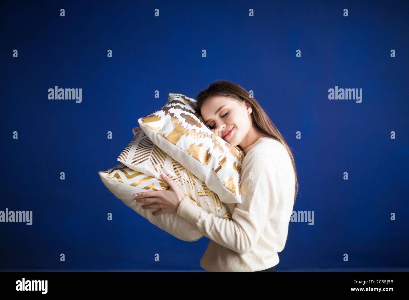 Donna adulta felice sdraiata sui cuscini e godendo di serenità e comfort Foto Stock