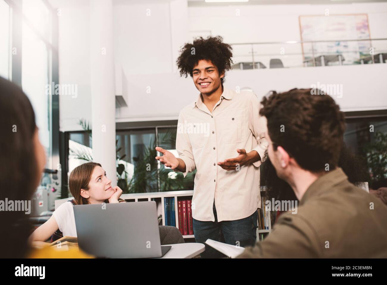 Gli studenti universitari stanno studiando in una libreria insieme. Concetto di lavoro di squadra e la preparazione Foto Stock