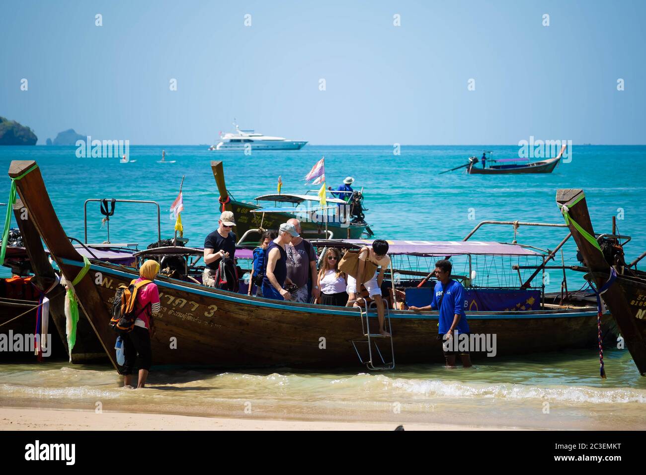 Provincia di Krabi, Railay Beach, Thailandia - 18 febbraio 2019: I turisti escono da un taxi boat a coda lunga. Tuffati in acqua sulla spiaggia sabbiosa di ao nang, giorno di sole e cielo azzurro. Foto Stock