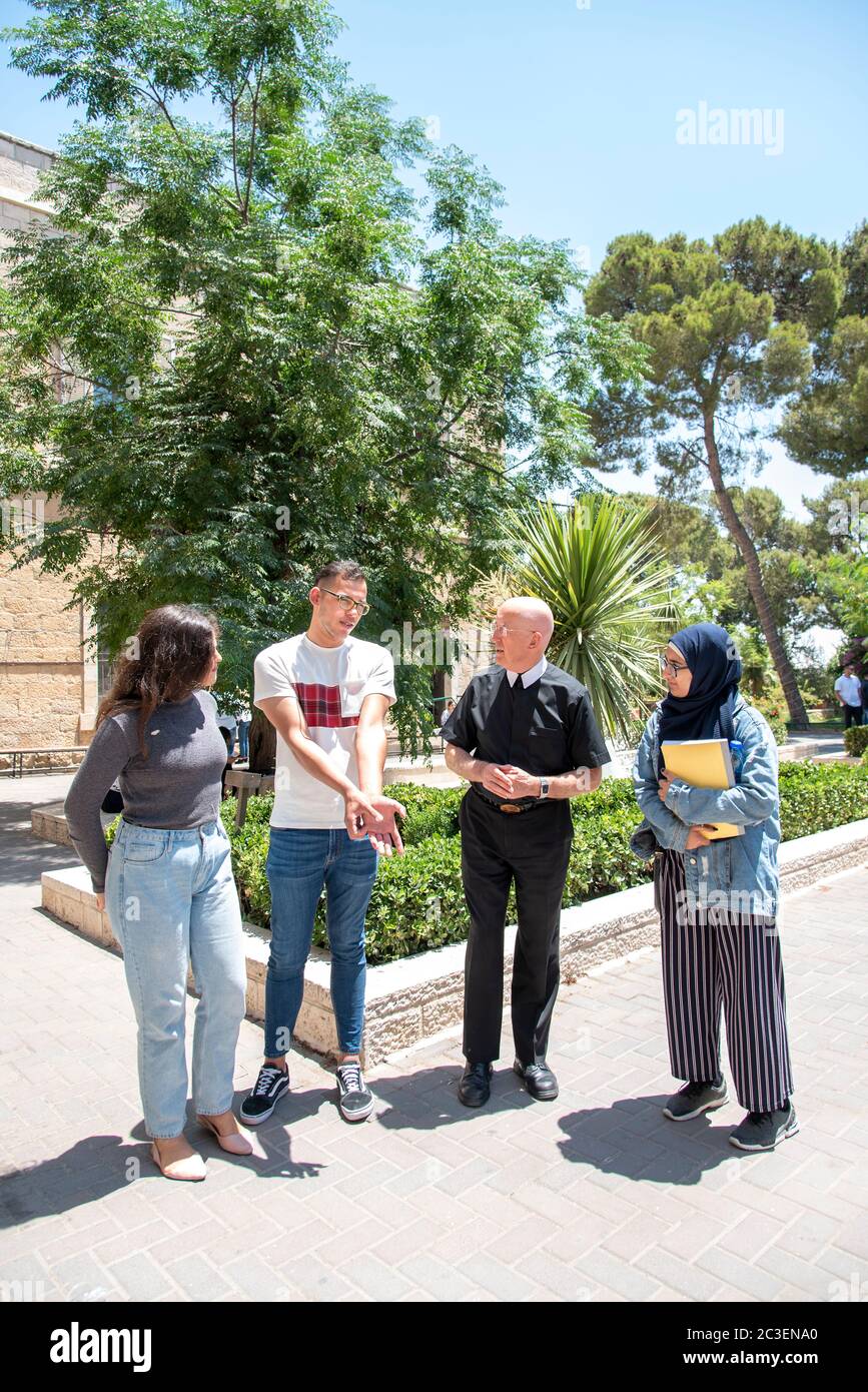 Fratel Peter Bray, vicecancelliere dell'Università di Betlemme, che parla con alcuni dei suoi studenti del campus. Foto Stock