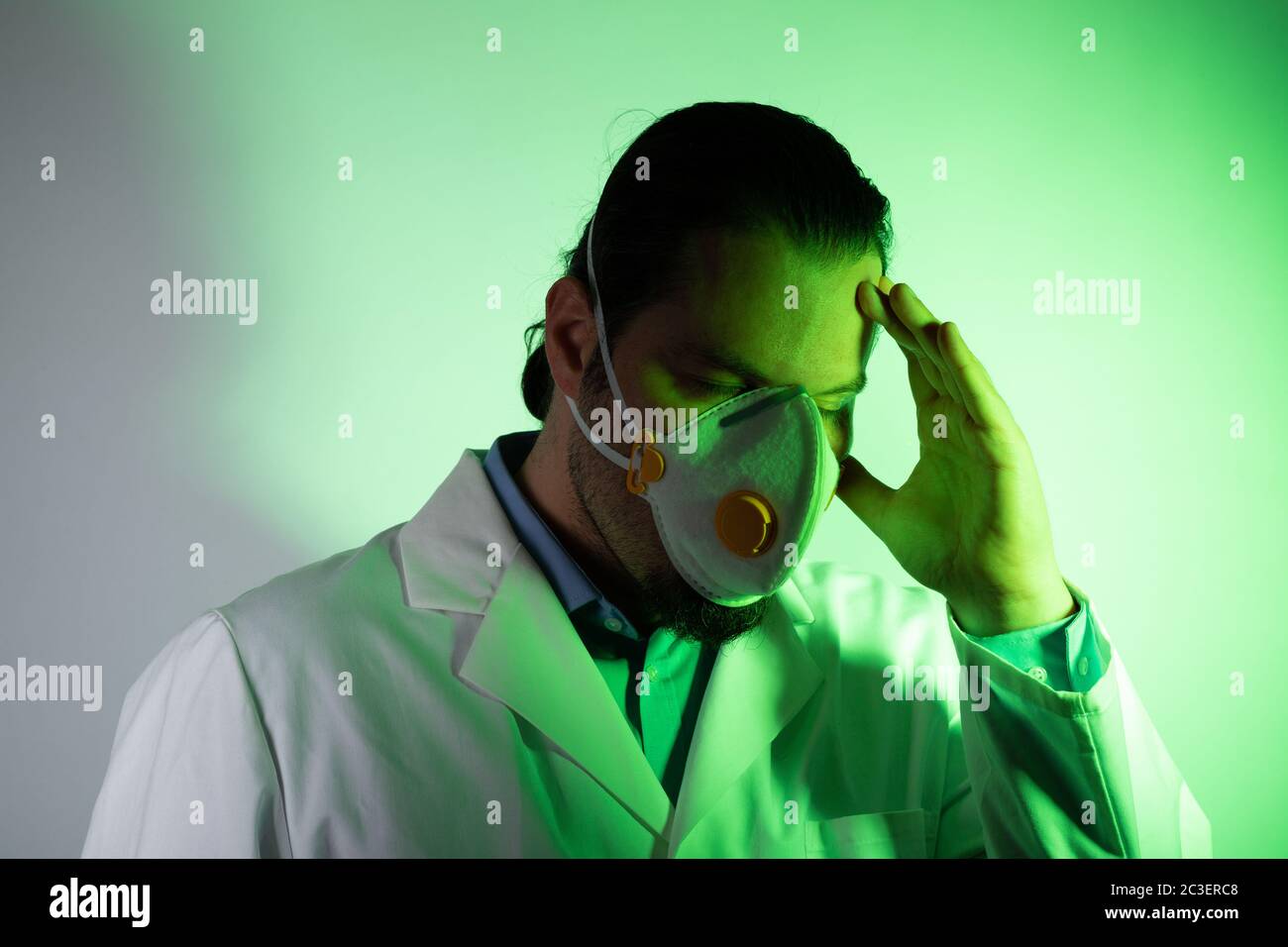 Medico che indossa una maschera respiratoria. Verde luce emergenza e medicina crisi concetto. Foto Stock