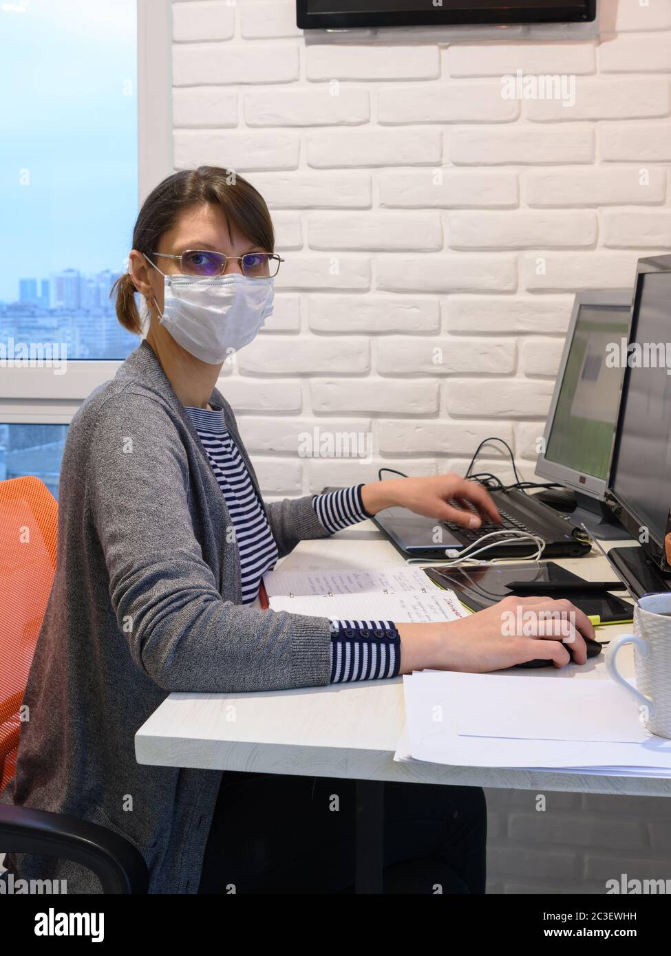 La ragazza messa in quarantena malata lavora al computer, guardava nella cornice Foto Stock