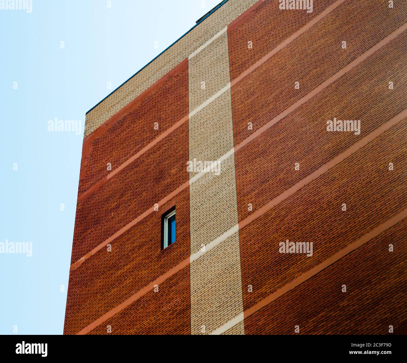 Alto muro con singola finestra sul cielo blu sullo sfondo Foto Stock