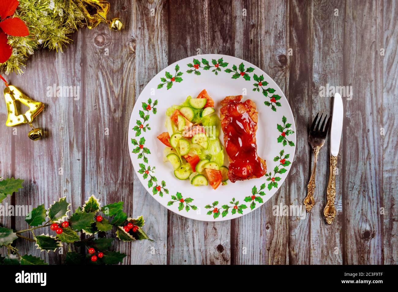 Pollo al forno con salsa barbecue e insalata su un tavolo di legno natalizio. Foto Stock