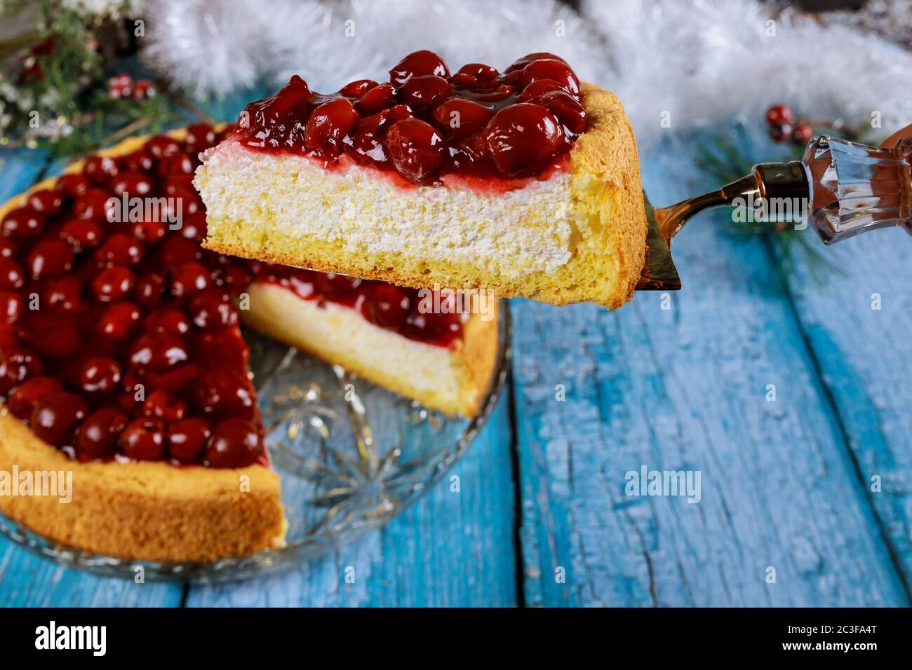 Pezzo di cheesecake di ciliegia sulla pala per torte. Contenuto di Natale. Foto Stock