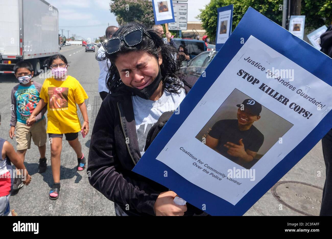 Los Angeles, California, Stati Uniti. 19 giugno 2020. Jennifer Guardado, che ha in mano un cartello con la foto del fratello Andres Guardado, grida durante una conferenza stampa della famiglia Andres Guardado, Che è stato ucciso a morte dal vice di Los Angeles County Sheriff fuori da un negozio di carrozzeria dove lavorava come guardia di sicurezza, a Gardena venerdì 19 giugno 2020. Credit: Ringo Chiu/ZUMA Wire/Alamy Live News Foto Stock