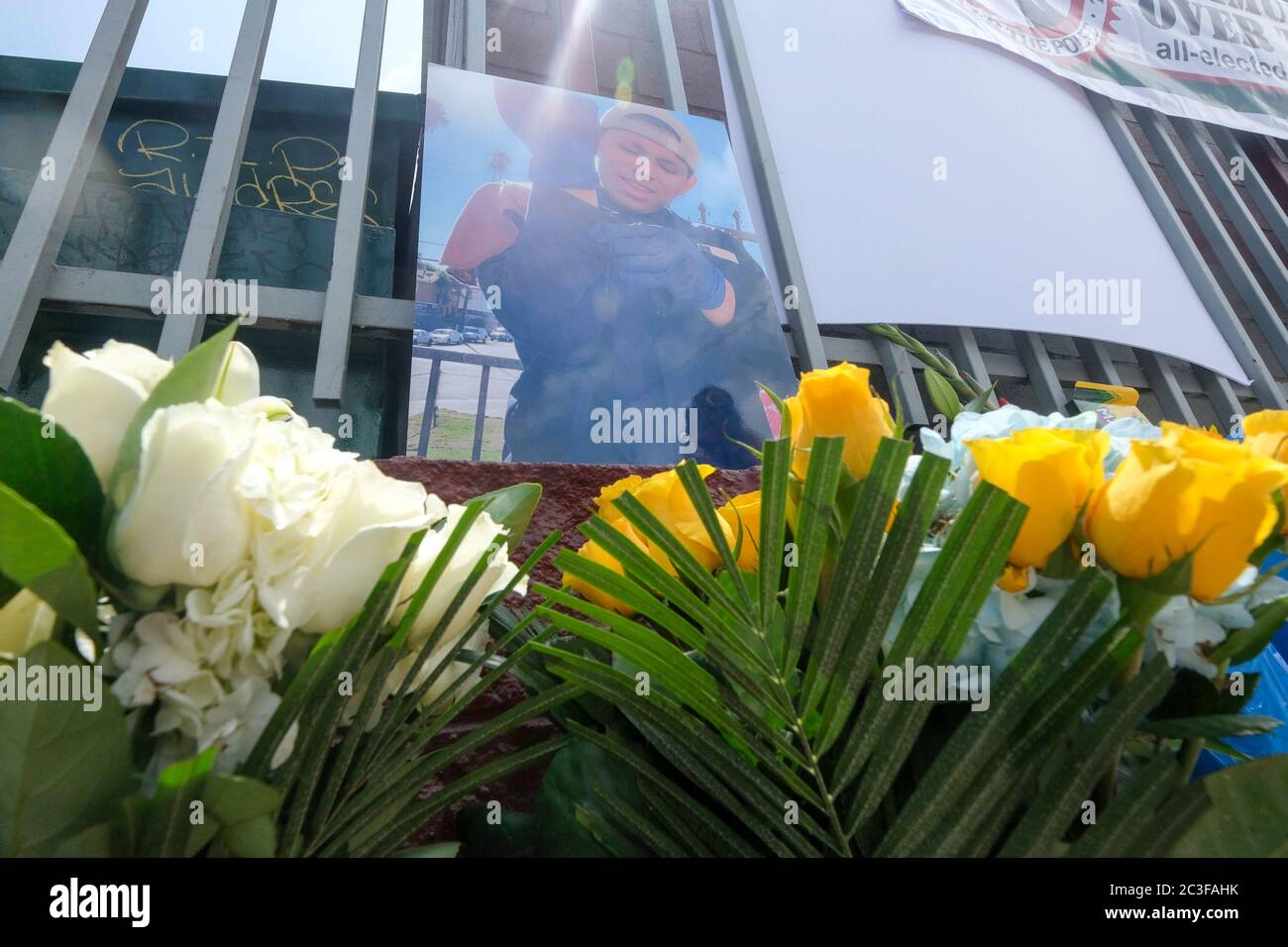 Los Angeles, California, Stati Uniti. 19 giugno 2020. Fiori e un'immagine di Andres Guardado sono suonati in un memoriale realizzato in occasione di una conferenza stampa della famiglia Andres Guardado, Che è stato ucciso a morte dal vice di Los Angeles County Sheriff fuori da un negozio di carrozzeria dove lavorava come guardia di sicurezza, a Gardena venerdì 19 giugno 2020. Credit: Ringo Chiu/ZUMA Wire/Alamy Live News Foto Stock