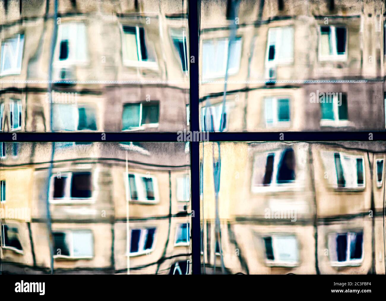 riflesso di case in una finestra di vetro Foto Stock