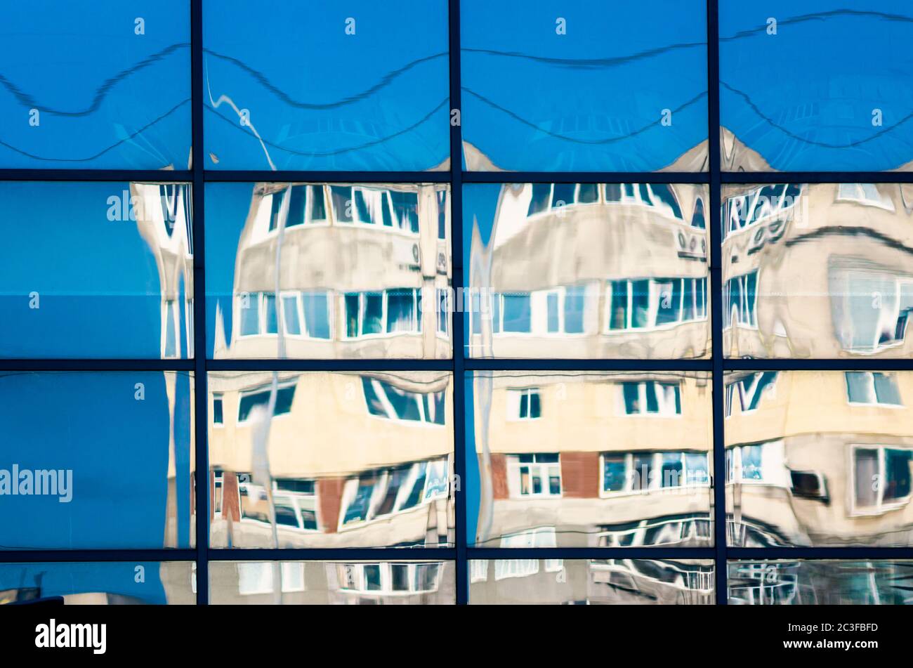riflesso di case in una finestra di vetro Foto Stock