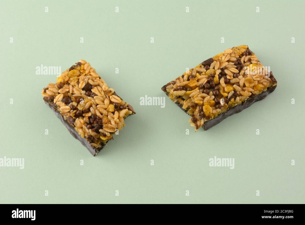Lo spuntino al cioccolato fondente e al riso candy bar si trova su uno sfondo verde chiaro Foto Stock