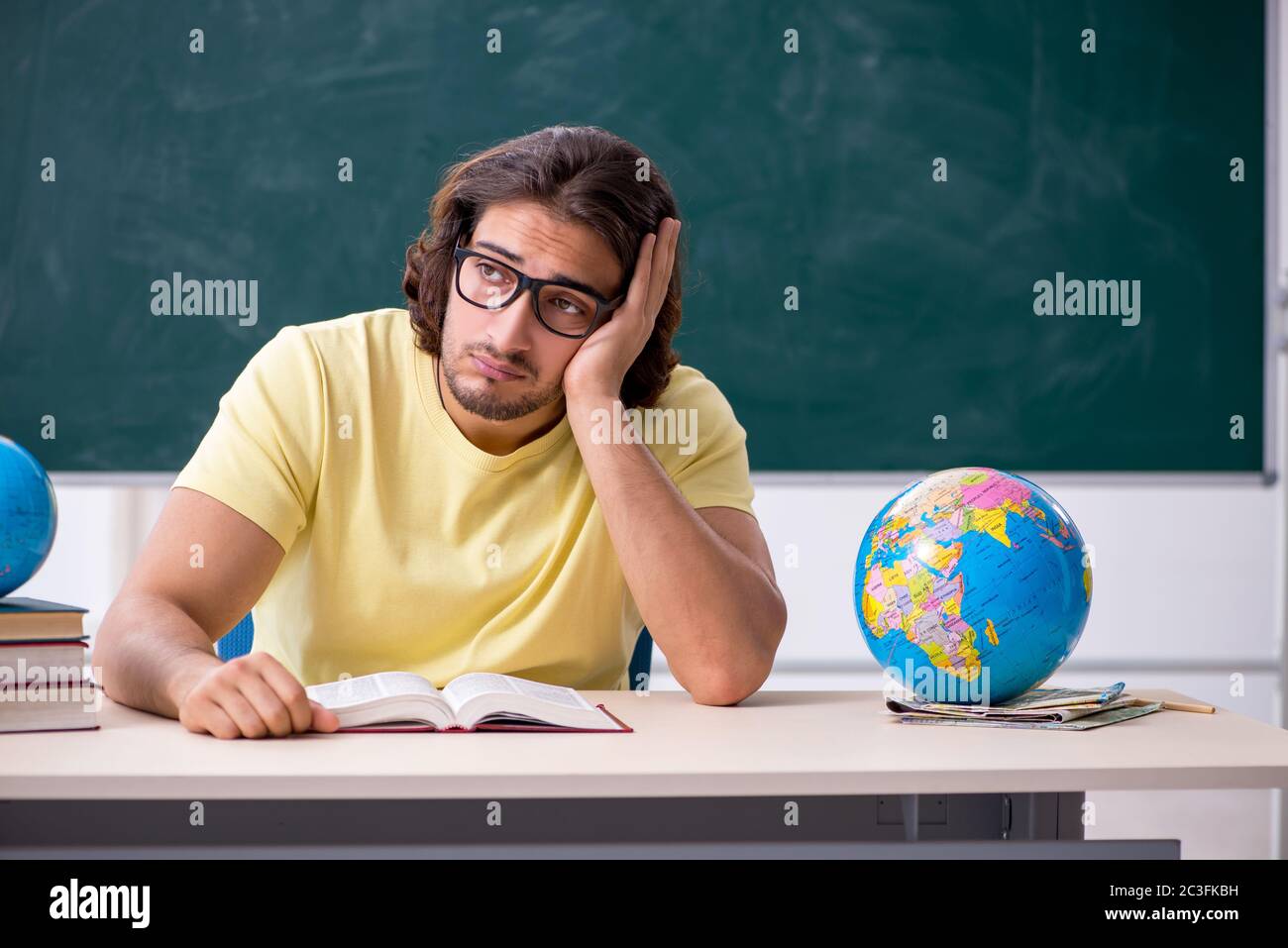 Giovane insegnante di geografia maschile di fronte al lavagna Foto Stock