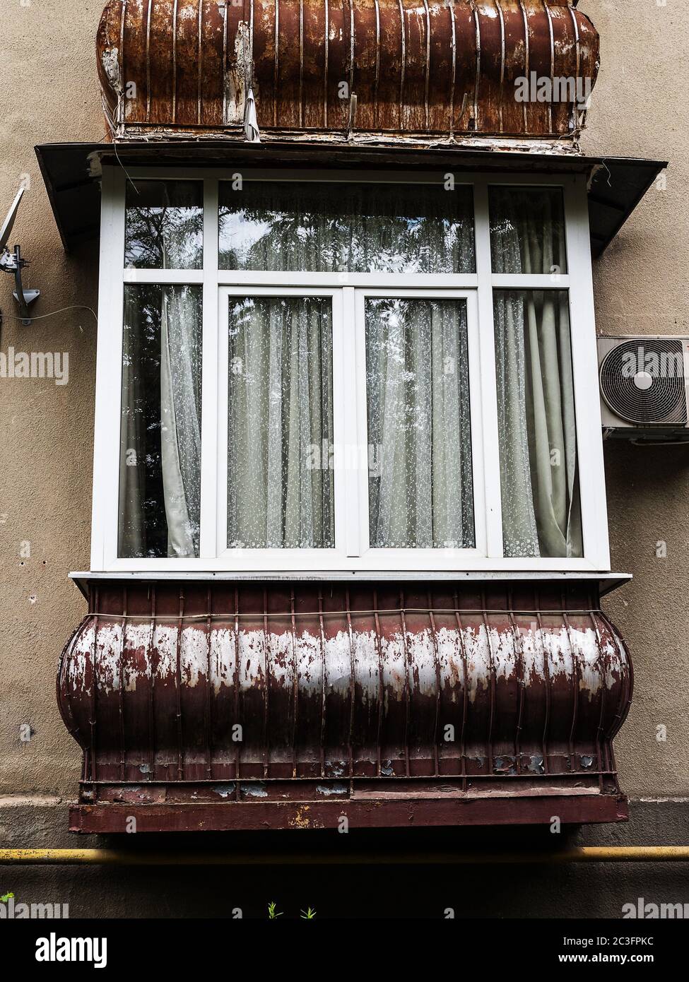 Balcone marrone in un vecchio edificio residenziale con nuove finestre Foto Stock