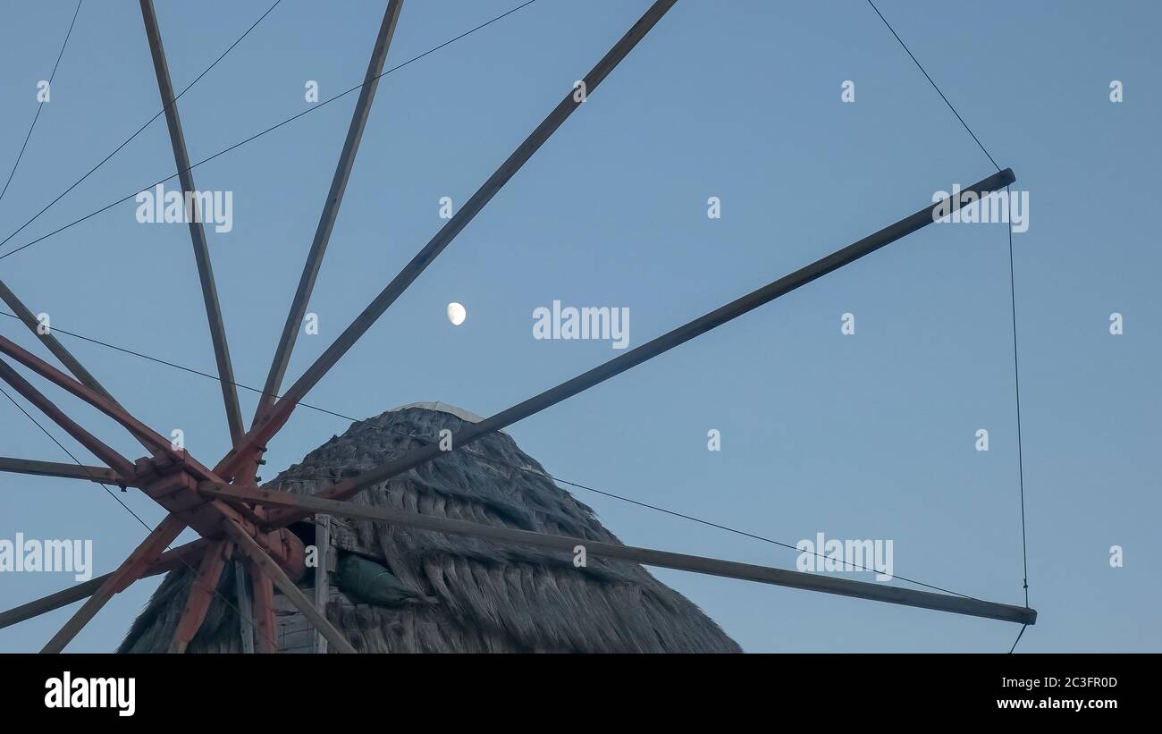 la luna e un primo piano degli storici mulini a vento a mykonos Foto Stock