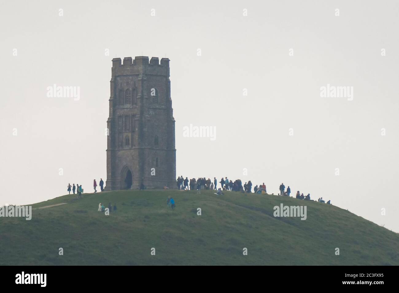 Glastonbury, Somerset, Regno Unito. 20 giugno 2020. Regno Unito Meteo. Un gran numero di persone si sono riunite sulla cima di Glastonbury Tor a Somerset per guardare l'alba solstizio d'estate, ma il cielo era denso di nuvole all'alba. Immagine: Graham Hunt/Alamy Live News Foto Stock